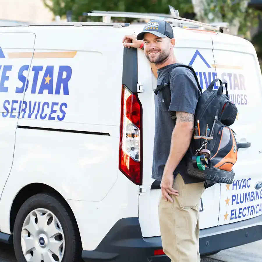 Plumber with a backpack full of tool standing next to a van