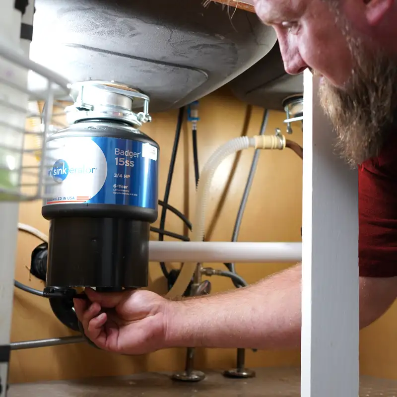 Plumber Fixing a Garbage Disposal