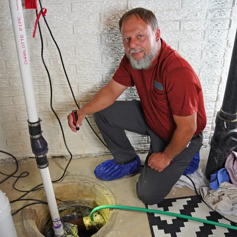 Plumbing with a flash light inspecting a sump pump