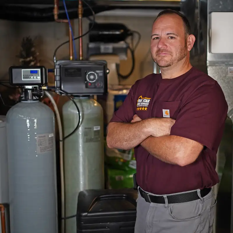 Plumber standing next to a water softener