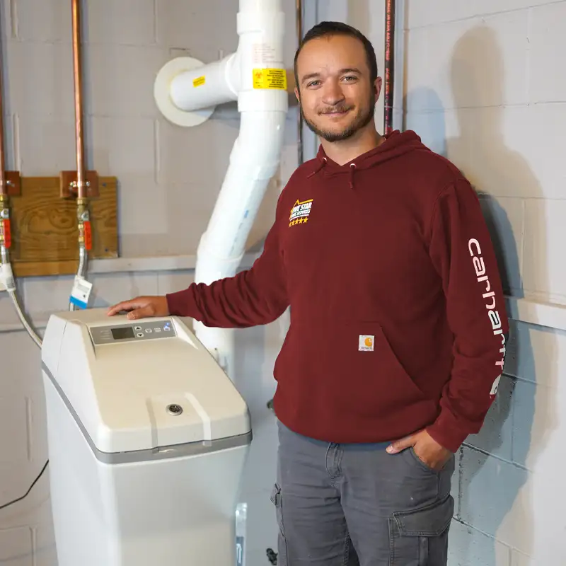 Plumber standing next to a water softener