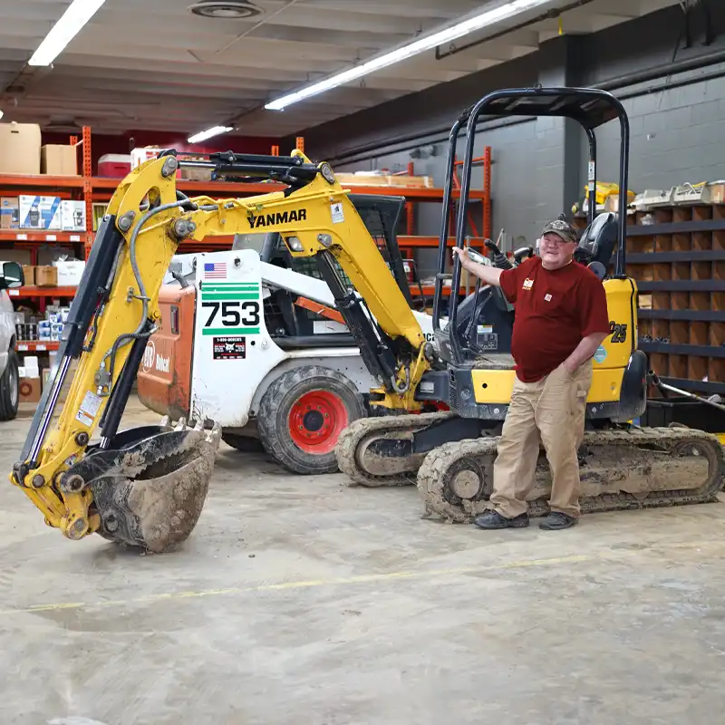 Plumber standing next to an excavator