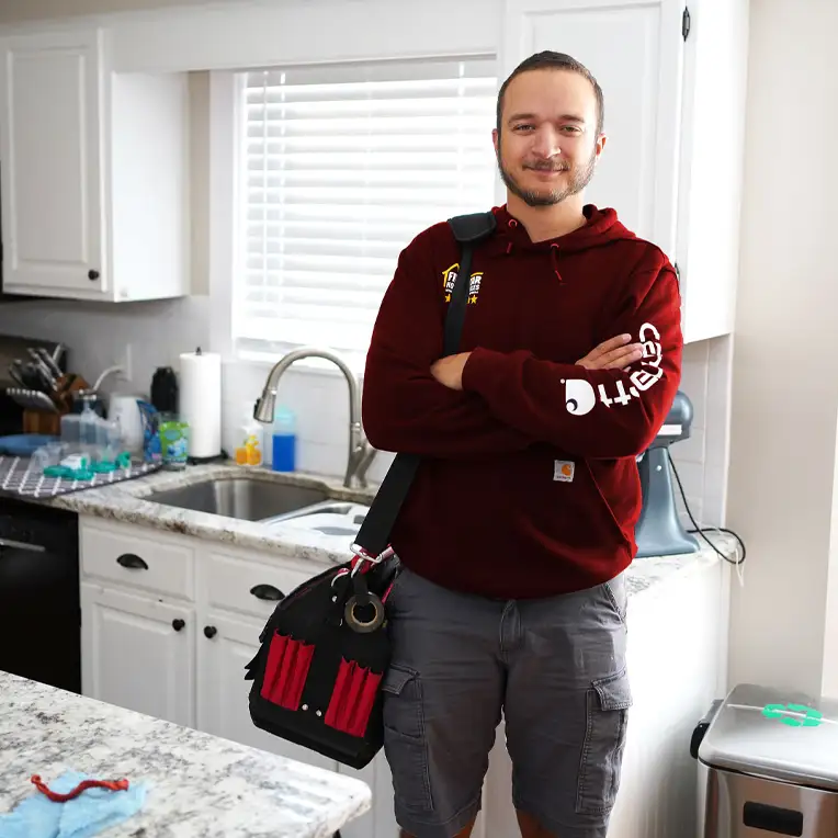 Plumber with tools standing next to a sink