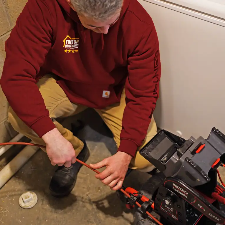 Plumber using video camera inspection equipment